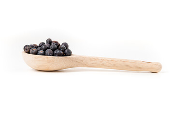 Juniper berries in a wood spoon isolated over white side view