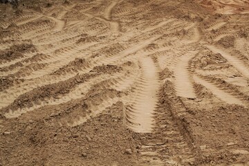 Tire track mark lines shape on dry sand background. Trail tyre imprint from heavy machinery. Vehicle shape. Road construction site backdrop concept. Trace of wheel pattern on mud. Nature texture.