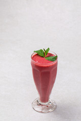 Glass of fresh berry smoothie with mint on white background