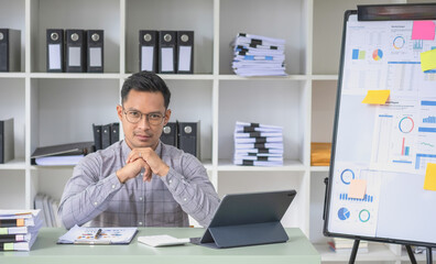 Marketing, Financial, Accounting, Planning, The company's president sits in his office with a tablet, calculator, pen, and graph paper attached to a blackboard for his work.