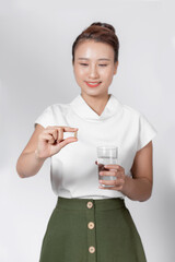 asian young woman holding a glass of water with vitamin has healthy life and she smile at you