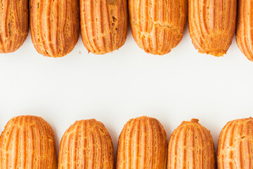 Eclair with custard on white background. Traditional French pastry as a textured background. Eclair with cream filling. Flat lay. Copy space for a free text