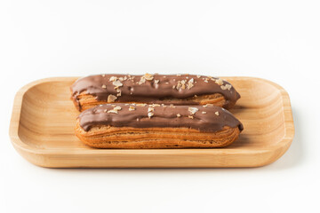 Traditional French pastry. Eclair with custard and chocolate icing isolated on white background. Eclair with cream filling covered with melted milk chocolate