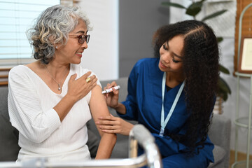 Doctor injecting diabetes treatment into upper arm of diabetic senior woman. Diabetes, healthcare and age concept