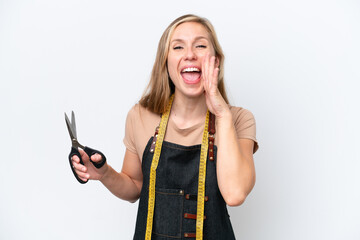 Young blonde seamstress woman isolated on white background shouting with mouth wide open