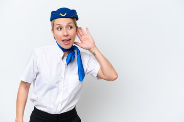Airplane blonde stewardess woman isolated on white background listening to something by putting hand on the ear