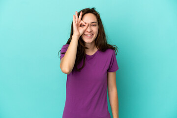 Young caucasian woman isolated on blue background showing ok sign with fingers