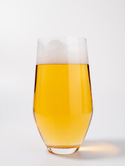 Glass of beer on a white background. A glass of light beer with foam.