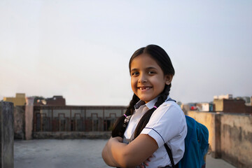 Happy Indian school girl standing with backpack