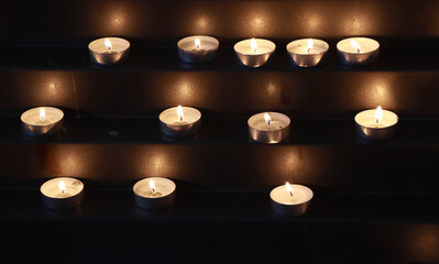 Many burning candles in the church - 551042965