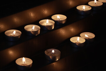 Many burning candles in the church - 551042980