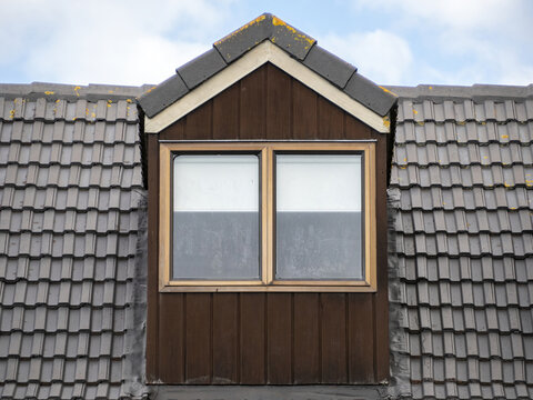 Brown gable roof dormer loft with window.