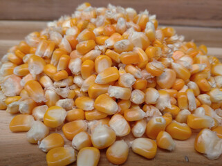 Pile of corn kernels on a wooden background