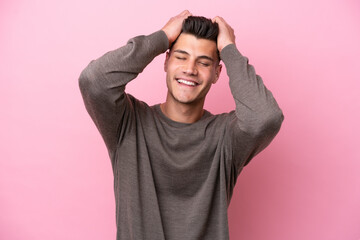 Young caucasian man isolated on pink background laughing