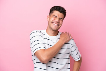 Young caucasian man isolated on pink background suffering from pain in shoulder for having made an effort