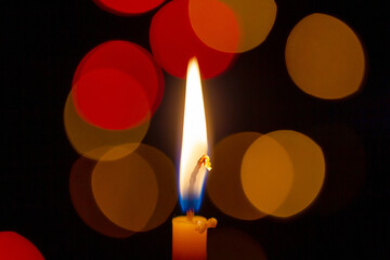 One candle burning brightly with bokeh background, closeup