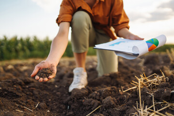 Female Hand of expert farmer collect soil and checking soil health before growth a seed of...