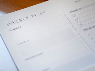 Close-up of weekly plan paper for organizing schedule and productivity planning. Week planner printable with priorities and to-do list for daily organization. - obrazy, fototapety, plakaty