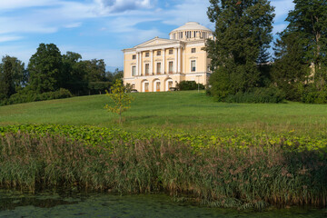 Fototapeta premium View of the Summer Palace of Emperor Paul I in Pavlovsky park from the Slavyanka River on a sunny summer day, Pavlovsk, Saint Petersburg, Russia