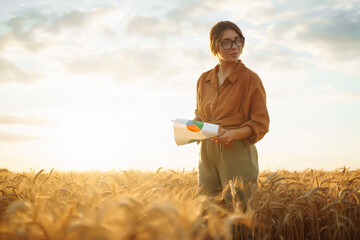 Farmer woman checking wheat field progress in a wheat field. Harvesting. Agro business. © maxbelchenko