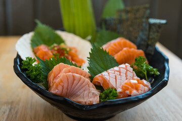 Fresh sliced salmon or salmon sashimi with salmon ikura or salmon egg in bowl set on table, Japanese food. Close up