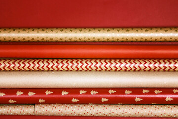 Rolls of red and brown wrapping paper for gifts on red background.