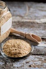 nutritional yeast in flakes, deactivated, not live, B vitamins, wood background, close-up, side view