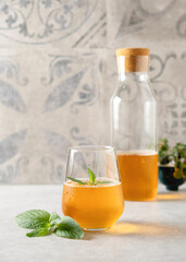 Kombucha, kombucha drink, healthy carbonated infusion with a sweet and sour taste, with mint on a gray background, vertical format