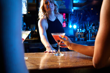 Bartender, nightclub and cocktail drink with mixologist worker at counter serving alcohol at a...