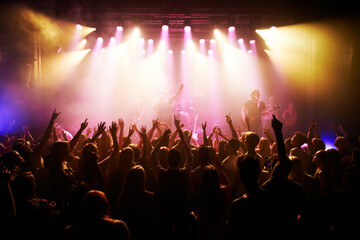 Festival, music and concert with energy of crowd cheering for live rock band on stage. Event, fans...