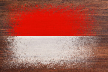 Flag of Monaco. Flag is painted on a wooden surface. Wooden background. Plywood surface. Copy space. Textured background