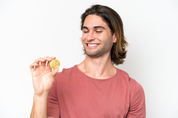 Young handsome man holding a Bitcoin isolated on white background with happy expression
