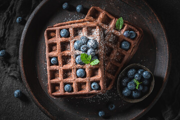 Sweet and brown dark waffles with fresh berries.