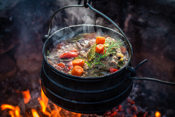 Delicious and hot hunter's stew on bonfire.