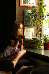 Indoor portrait of a cute thoughtful girl near the window © Lydia Sokor