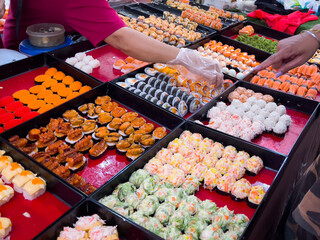 Arm of street market vendor and customer on sushi stall. Traditional Japanese food variety concept