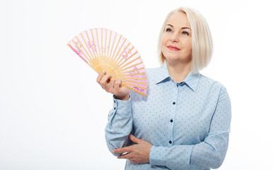 Beautiful middle aged woman with menopause blowing by fan. Hormone replacement therapy and mature woman healthcare. Mid age happy women lifestyle. Senior woman isolated on white. - obrazy, fototapety, plakaty