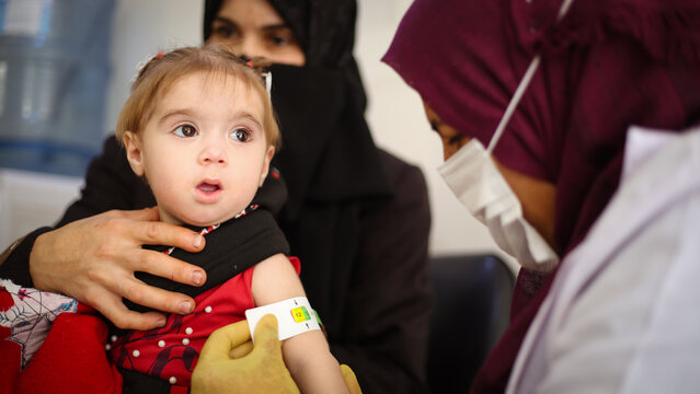 Doctor examines child malnutrition. Measuring malnutrition using strap MUAC mid-upper-arm-circumference.	
