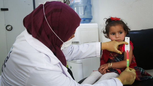 Doctor examines child malnutrition. Measuring malnutrition using strap MUAC mid-upper-arm-circumference.	
