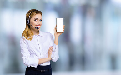 Image of customer support phone operator in headset holding showing smartphone cell phone mobile...