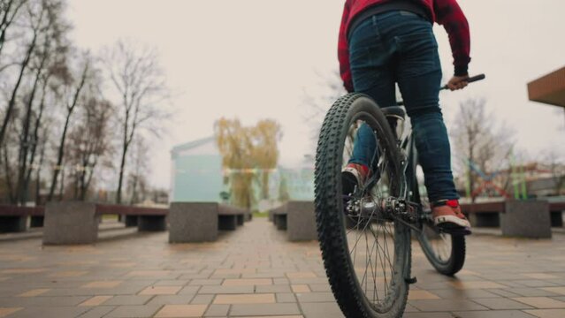 bike riding in park, failure jump with bicycle on bench, bmx bike tricks, teen boy is training and falling on ground