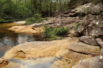 Naklejka na ściany i meble Creek with small pond amidst rocks. Wild forest with trees and vegetation. Mountainous region of Minas Gerais, Diamantina