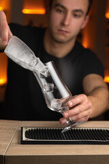 Bartender making a cool cocktail with help of the bar equipment