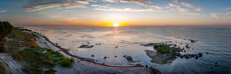 The coast of Ruhnu at sunset. Estonia, Baltic sea. Clear blue sky, pink clouds. Panoramic view. Nature, eco tourism, travel destinations, recreation themes.