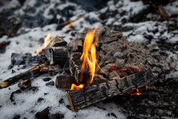 The flame of a fading fire on a frosty winter evening