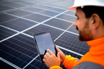 Solar panels installation for sustainable energy. Electrical engineer holding digital tablet with...