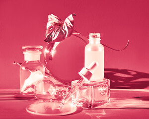 Viva Magenta color of the year 2023. Moisturizing serum, glass bottles with distorted leaves. with...