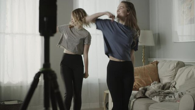 Tilt up to girls recording dance routine on cell phone for social media / Cedar Hills, Utah, United States
