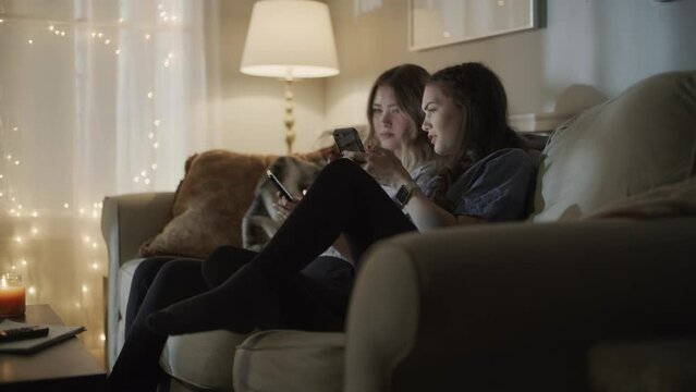 Surprised girls laughing at social media on cell phone / Cedar Hills, Utah, United States