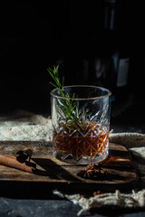 cocktail with whiskey and rasmarino on a dark background